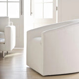 Modern white sofa in a bright living room with large windows.