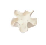 White ceramic vase with wavy design on a white background