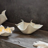 Three ceramic bowls on a wooden surface with a dark wall in the background