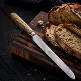 Serrated bread knife with wooden handle on a cutting board with sliced bread