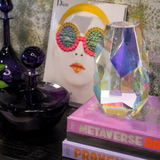 Decorative setup with crystal vases, books, and a Dior ad on a reflective surface.
