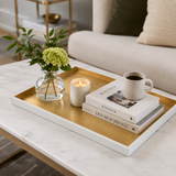 Tray with a candle, coffee cup, and books on a marble surface