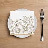 Napkin with floral design on a plate with a fork on a wooden table